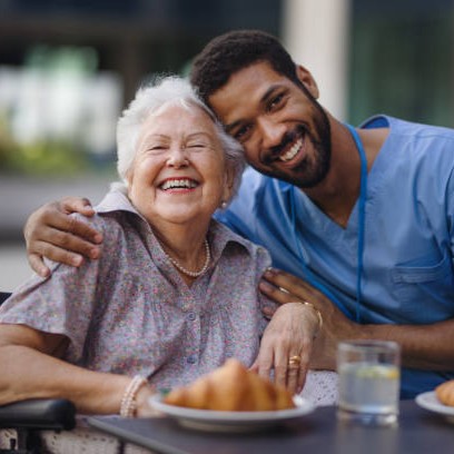 Caregiver having breakfast with his client at a cafe.